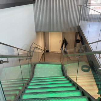 Green backlit stairs with clear-PEP ECO PC stage panels MoxieSurfaces - clear-PEP ECO PC stage - garage backlit stairs