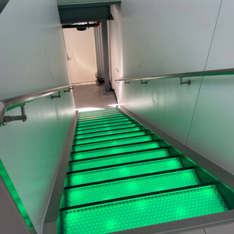 Green backlit stairs with clear-PEP ECO PC stage panels MoxieSurfaces - clear-PEP ECO PC stage - garage backlit stairs