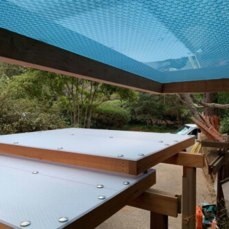 clear-PEP ECO panels in clear blue and satin opal white, complementing a wooden residence with elegant awnings and canopies MoxieSurfaces - clear-PEP ECO panels - Digigloramo Residence