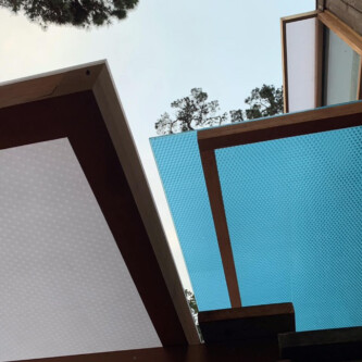 clear-PEP ECO panels in clear blue and satin opal white, complementing a wooden residence with elegant awnings and canopies MoxieSurfaces - clear-PEP ECO panels - Digigloramo Residence