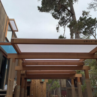 clear-PEP ECO panels in clear blue and satin opal white, complementing a wooden residence with elegant awnings and canopies MoxieSurfaces - clear-PEP ECO panels - Digigloramo Residence