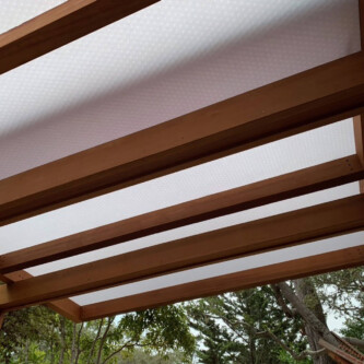 clear-PEP ECO panels in clear blue and satin opal white, complementing a wooden residence with elegant awnings and canopies MoxieSurfaces - clear-PEP ECO panels - Digigloramo Residence